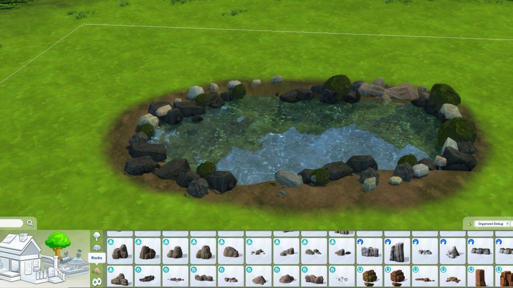 A screenshot showing the pond with rocks surronding the edges. There are various types of rocks.