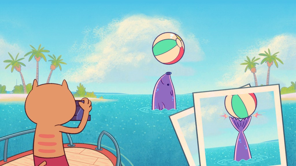 An orange cat standing on a boat deck with a camera taking pictures of a purple seal in water with a beach ball.